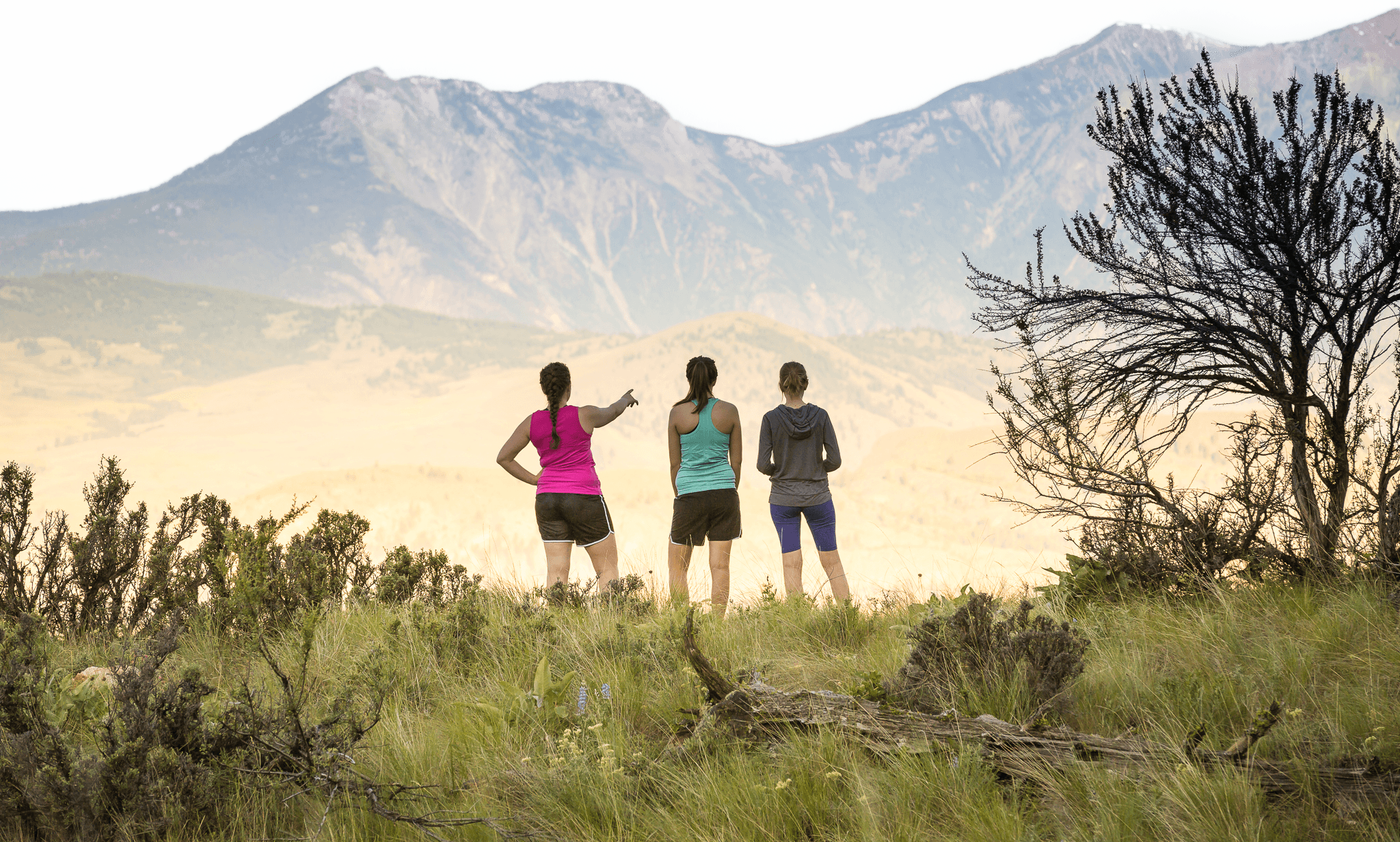 Three hikers overlooking the Osoyoos valley at sunset